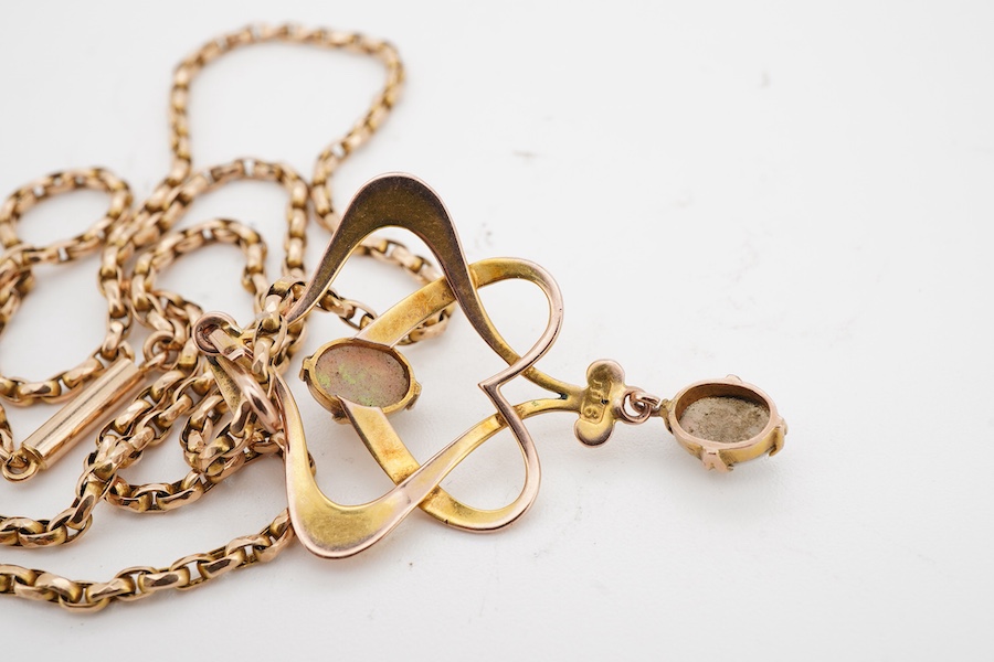 An Art Nouveau gold and opal pendant and chain, early 20th century, the pendant of sinuous design, set with two cabochon opals, to a gold belcher link chain necklace, chain length 45cm, stamped 15ct, pendant 4.7cm, stamp